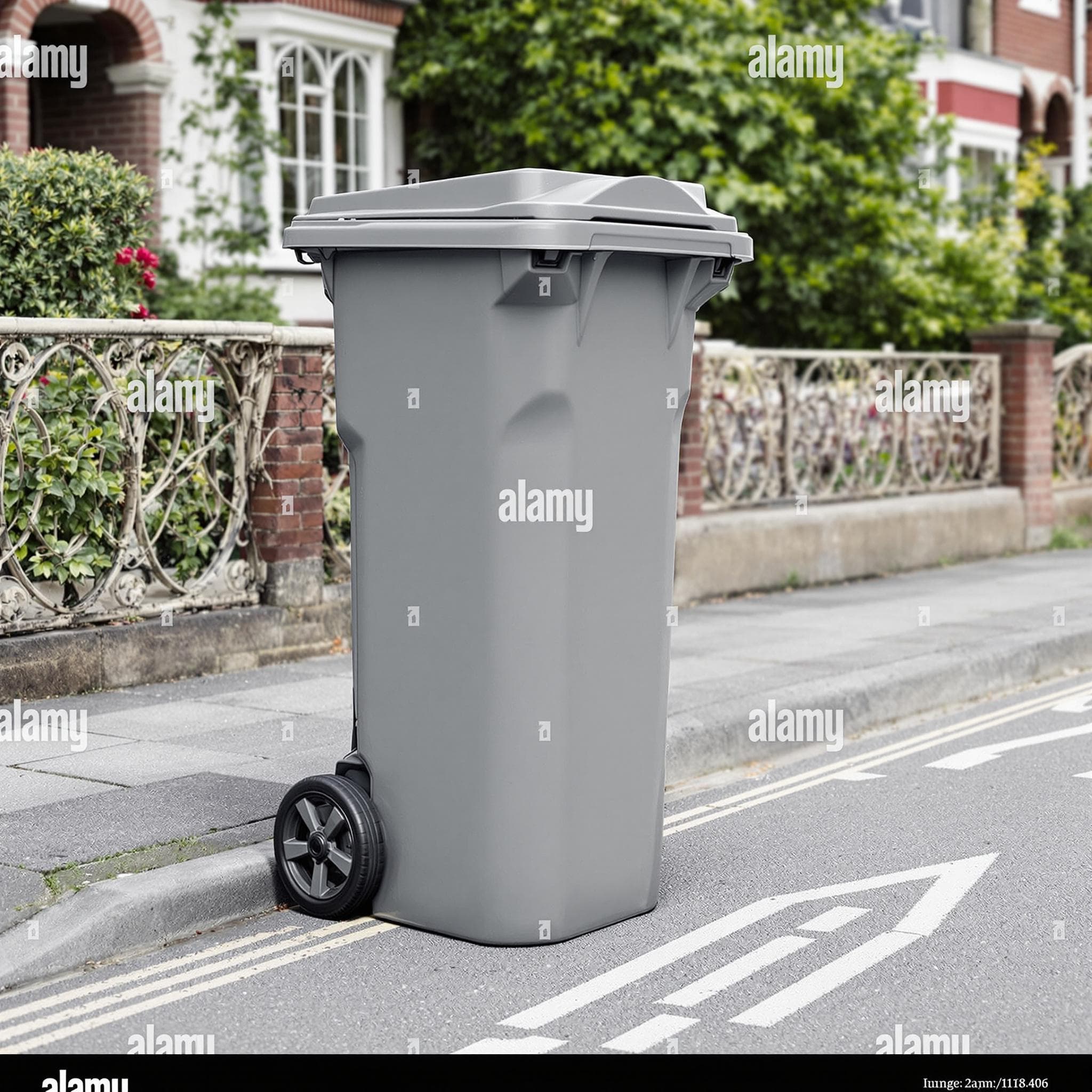 Eine graue Restmülltonne steht an einer deutschen Straße, der Deckel ist leicht geöffnet und zeigt unsortierten Hausmüll