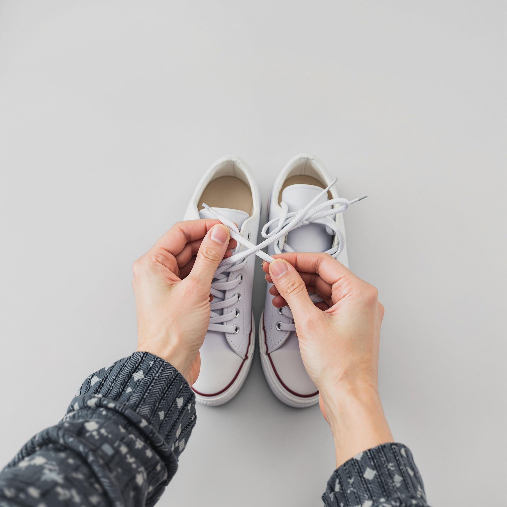 Nahaufnahme von einem Paar Schnürschuhe, die an den Schnürsenkeln zusammengebunden sind.